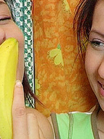 Two cute brunette teenies are playing with banana and toys